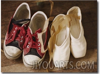 A Pair of Tennis Shoes with Red Laces Sits Next to a Pair of Ballet Slippers