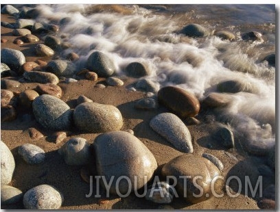 Water Washes up on Smooth Stones Lining a Beach