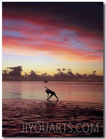 Woman Doing Yoga by Ocean at Sunset