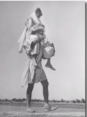 Sikh Carrying His Wife on Shoulders in Convoy Migrating to East Punjab After the Division of India