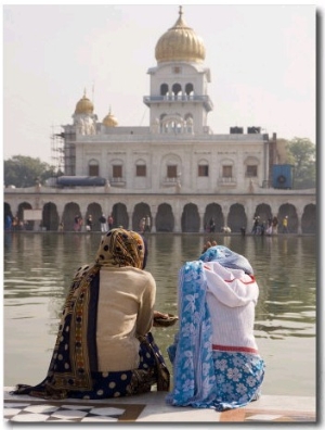 ITwo Women Sitting Beside Holy Water Pool at Sikh Gurdwara Bangla Sahib Temple in New Delhi