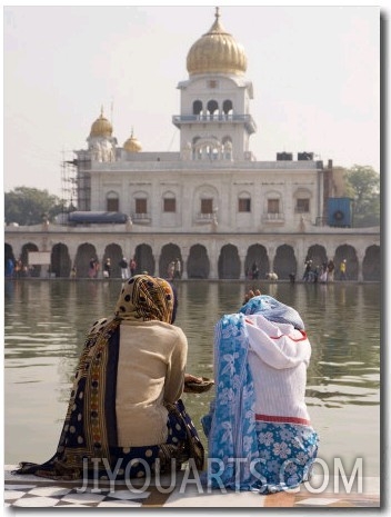 ITwo Women Sitting Beside Holy Water Pool at Sikh Gurdwara Bangla Sahib Temple in New Delhi