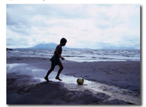 Boy Kicking Soccer Ball on Beach, Lake Nicaragua, Granada, Nicaragua