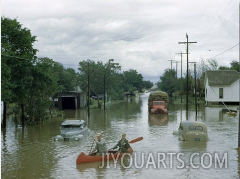 Men Paddle Canoe Down Street Submerged by Flash Flood in May 1951