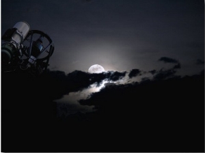 Telescope Pointed Out to the Night Sky with Moon and Clouds