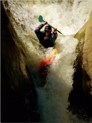 A Kayaker Sails over a Waterfall and is Headed for the Rough White Water Below