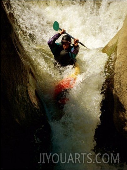A Kayaker Sails over a Waterfall and is Headed for the Rough White Water Below