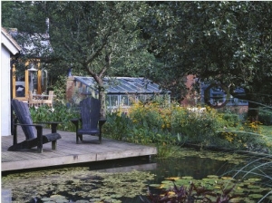 View across Lily Pool to Deck with Adirondack Chairs, in the Background Is the Main Greenhouse