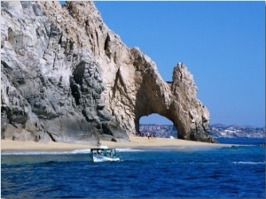 Tour Boat in the Water by El Arco, a Natural Arch at Land